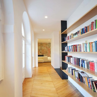 Esempio di un ingresso o corridoio mediterraneo con pareti bianche, parquet chiaro e pavimento beige