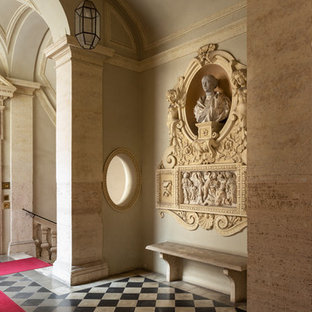 Esempio di un ingresso mediterraneo con pareti beige, una porta a due ante, una porta nera e pavimento multicolore