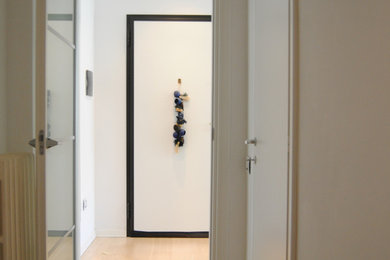 Esempio di un ingresso o corridoio minimalista con pareti bianche e parquet chiaro
