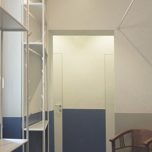 Cette image montre un petit hall d'entrée design avec un mur blanc, un sol en carrelage de porcelaine, une porte double, une porte en bois foncé et un sol turquoise.