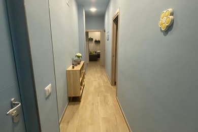 Foto di un piccolo ingresso o corridoio minimalista con pareti blu e pavimento in gres porcellanato