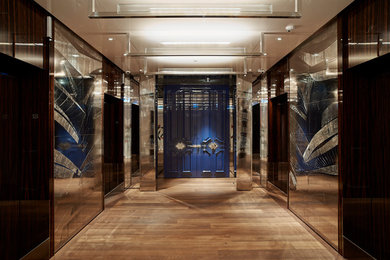 Immagine di un ingresso o corridoio minimal con pavimento in legno massello medio, una porta a due ante e una porta blu