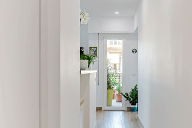 Foto de recibidores y pasillos contemporáneos de tamaño medio con paredes blancas y suelo de baldosas de porcelana