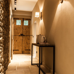 Ispirazione per un corridoio rustico con pareti beige, una porta a due ante e una porta in legno bruno