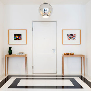 Esempio di un ingresso contemporaneo con pareti bianche, una porta singola, una porta bianca e pavimento multicolore