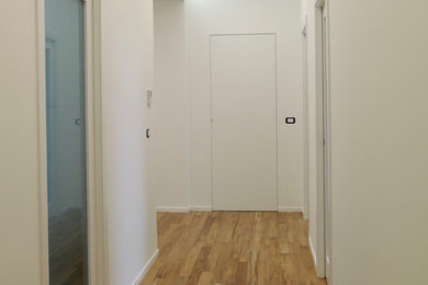 Inspiration for a mid-sized contemporary medium tone wood floor hallway remodel in Bari with white walls