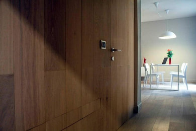 Ispirazione per un ingresso con anticamera minimalista di medie dimensioni con pareti grigie, pavimento in legno massello medio, una porta singola, una porta in legno bruno e pavimento multicolore