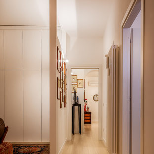 Immagine di un grande ingresso o corridoio contemporaneo con pareti bianche, parquet chiaro e pavimento beige