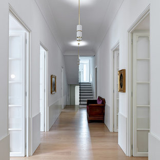 Esempio di un grande ingresso o corridoio design con pareti bianche, parquet chiaro e pavimento beige