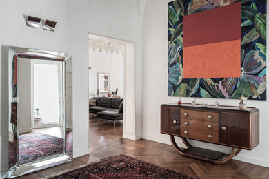 フィレンツェにあるミッドセンチュリースタイルのおしゃれな玄関ロビー (白い壁、濃色無垢フローリング、茶色い床) の写真