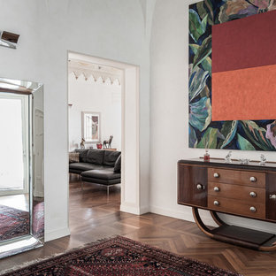 Immagine di un ingresso moderno con pareti bianche, parquet scuro e pavimento marrone