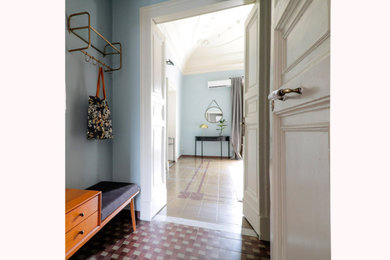 Ispirazione per un ingresso con pareti grigie, pavimento in cemento, una porta a due ante, una porta bianca, pavimento multicolore e soffitto a cassettoni