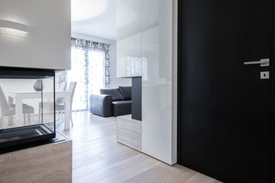 Immagine di un ingresso minimalista di medie dimensioni con parquet chiaro e pavimento beige