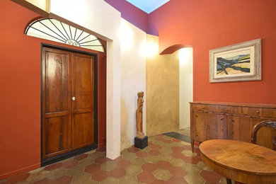 Idee per un grande ingresso o corridoio eclettico con pareti rosse, pavimento in terracotta e pavimento multicolore