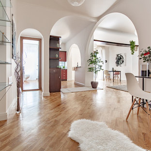 Esempio di un ingresso minimal con pareti bianche, pavimento in legno massello medio e pavimento marrone