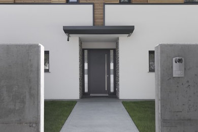 Immagine di una porta d'ingresso design di medie dimensioni con pareti bianche, una porta singola e una porta grigia