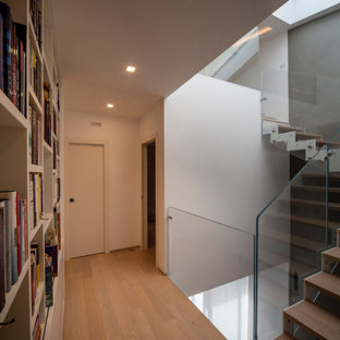Immagine di un ingresso o corridoio contemporaneo di medie dimensioni con pareti bianche, parquet chiaro e pavimento marrone