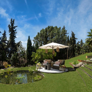 Diseño de jardín tropical, en ladera, con estanque