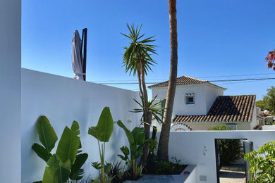 Diseño de jardín minimalista de tamaño medio con macetero elevado, exposición parcial al sol y piedra decorativa