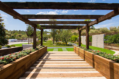 Imagen de jardín tropical grande en patio delantero con exposición total al sol
