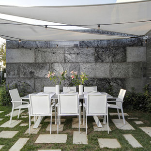 Diseño de jardín minimalista, en patio trasero, con exposición reducida al sol y adoquines de hormigón