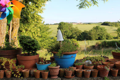 Réalisation d'un jardin en pots champêtre avec une exposition partiellement ombragée.