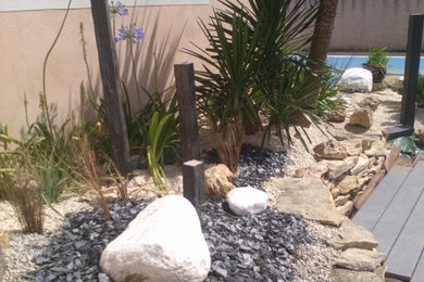 Idées déco pour un petit jardin latéral méditerranéen l'été avec une exposition ensoleillée et du gravier.