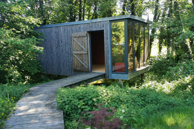 Cette image montre un jardin nordique de taille moyenne avec une exposition partiellement ombragée et une terrasse en bois.