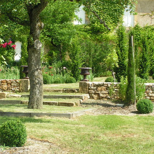 Cette image montre un grand jardin à la française traditionnel l'été avec une exposition ombragée et des pavés en pierre naturelle.