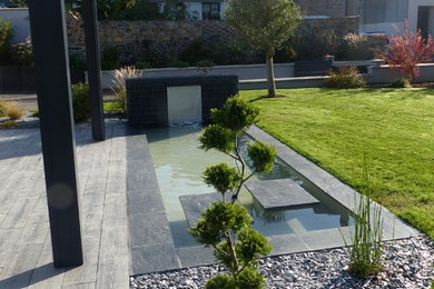 Réalisation d'un jardin avant design de taille moyenne avec un bassin, une exposition ensoleillée et des pavés en pierre naturelle.