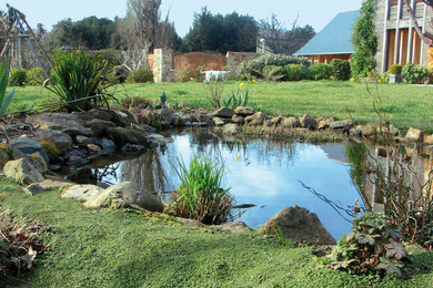 Idées déco pour un grand jardin classique avec un bassin et des pavés en pierre naturelle.