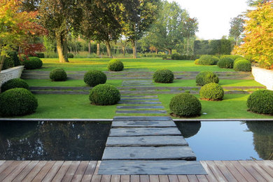 Cette photo montre un grand jardin moderne avec un point d'eau, une exposition ombragée, une pente, une colline ou un talus et des pavés en pierre naturelle.