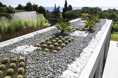 Aménagement d'un jardin sur toit contemporain de taille moyenne avec pierres et graviers, une exposition ensoleillée et une clôture en pierre.