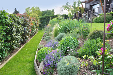 Inspiration pour un jardin style shabby chic de taille moyenne avec une pente, une colline ou un talus et une exposition ensoleillée.