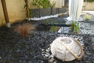 Aménagement d'un petit jardin en pots arrière asiatique au printemps avec une exposition ensoleillée et un paillis.