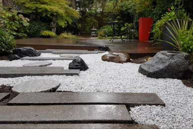 Cette image montre un jardin arrière asiatique de taille moyenne avec un bassin, une exposition partiellement ombragée et un gravier de granite.