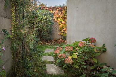 Ejemplo de jardín clásico de tamaño medio en patio trasero con exposición reducida al sol y adoquines de hormigón