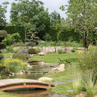 Cette image montre un grand jardin asiatique l'été avec un bassin, une exposition ensoleillée et des pavés en pierre naturelle.