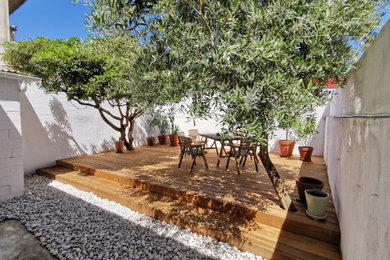 Cette photo montre un jardin sur cour méditerranéen de taille moyenne avec une terrasse en bois.