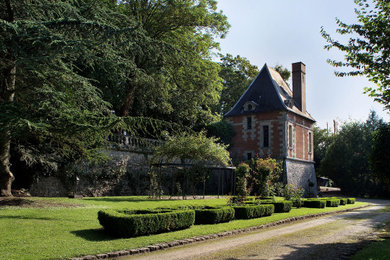 Aménagement d'un très grand jardin à la française classique l'été avec une exposition ensoleillée.