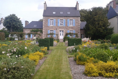 Large traditional back formal full sun garden for spring in Rennes with a garden path.