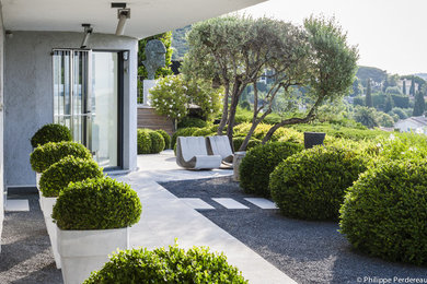 Cette image montre un jardin design avec un foyer extérieur, une exposition ensoleillée et du gravier.