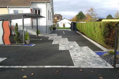 Réalisation d'un jardin à la française latéral design avec une exposition ensoleillée et des pavés en béton.