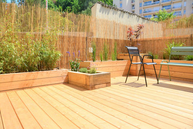 Réalisation d'un petit jardin sur cour minimaliste avec une exposition ensoleillée et une terrasse en bois.