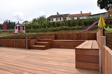 Idée de décoration pour un jardin arrière design de taille moyenne avec un foyer extérieur, une exposition ensoleillée et une terrasse en bois.