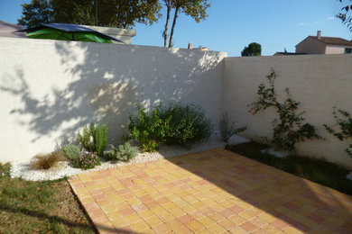 Modelo de jardín mediterráneo de tamaño medio en verano en patio trasero con exposición total al sol