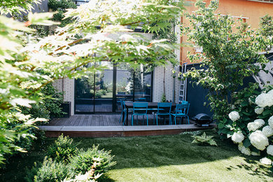 Inspiration pour un jardin design avec une exposition partiellement ombragée et une terrasse en bois.
