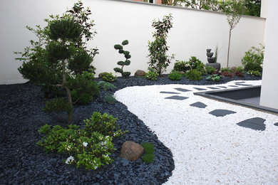 Réalisation d'un jardin arrière asiatique de taille moyenne avec un point d'eau, une exposition partiellement ombragée et du gravier.