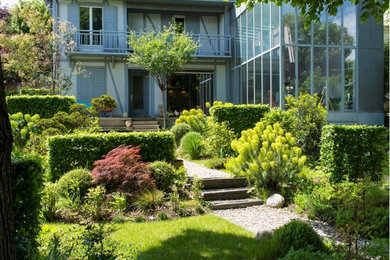 Diseño de camino de jardín minimalista de tamaño medio en patio delantero con jardín francés y gravilla