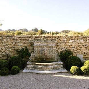 Idée de décoration pour un grand jardin arrière méditerranéen avec un point d'eau et du gravier.
